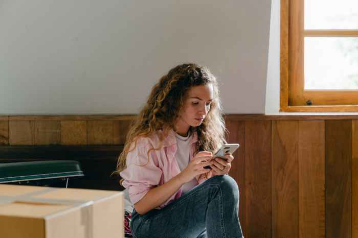 young woman using smartphone in new house